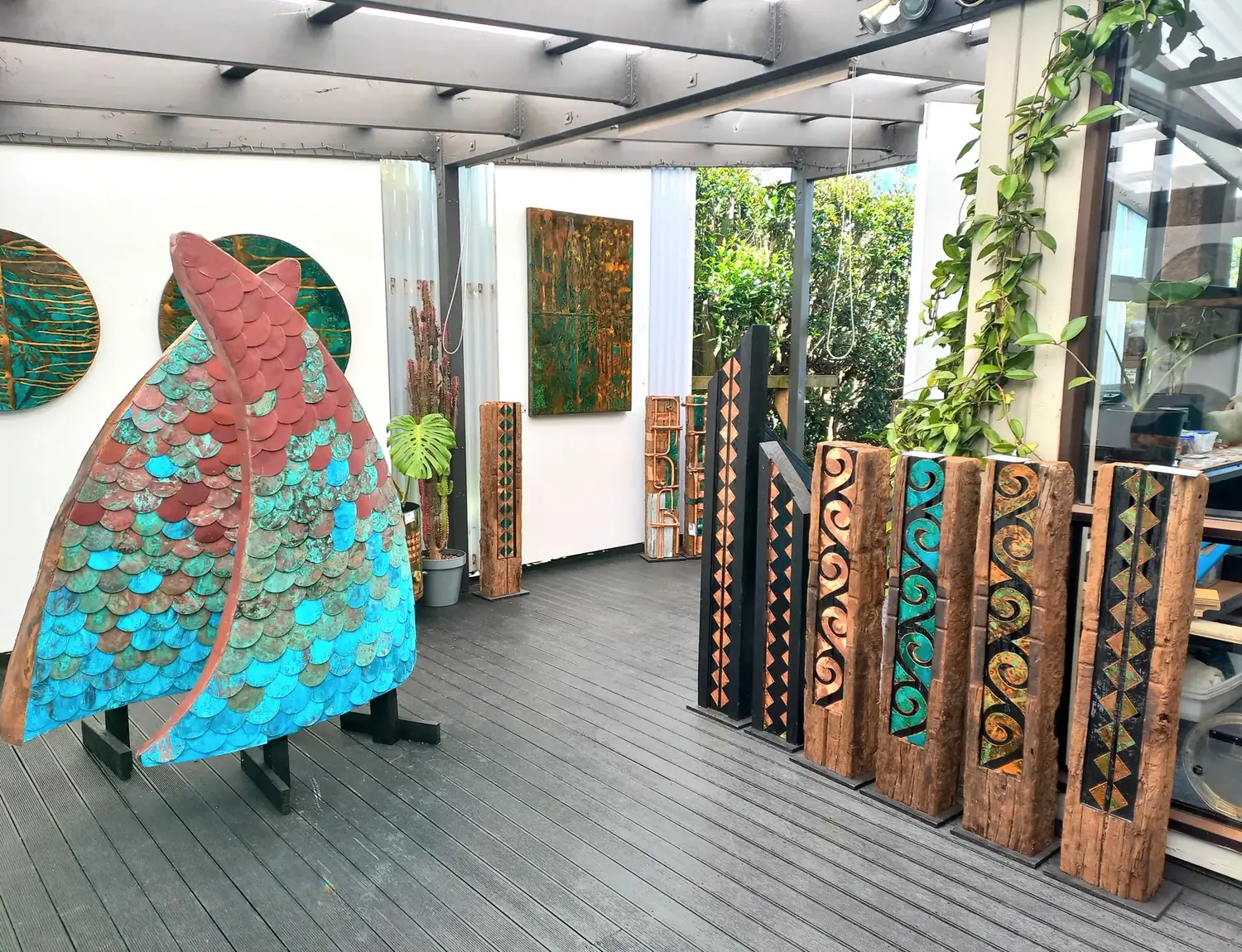 Inside the Isaac Weston Art Gallery, copper wall works and carved totems lining the deck